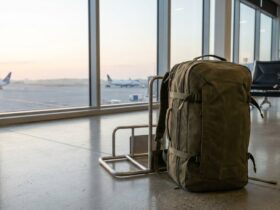 Travel backpack standing beside a cabin bag sizer at a sunlit airport gate